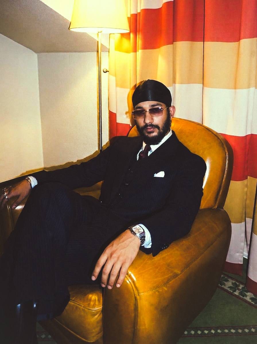 Jaidev Bhogal in a pinstripe suit in a leather armchair